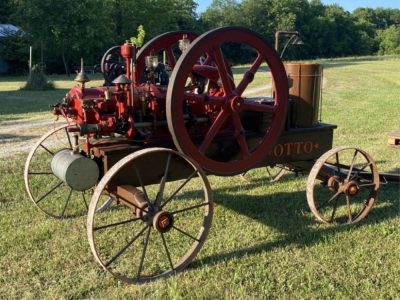 A red gas engine on a grassy field